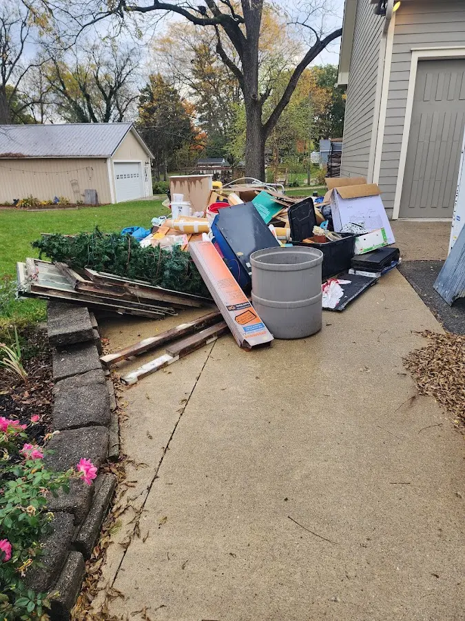 Dumpster being loaded with debris for 12 Yard Dumpster Rental in Saranac Lake